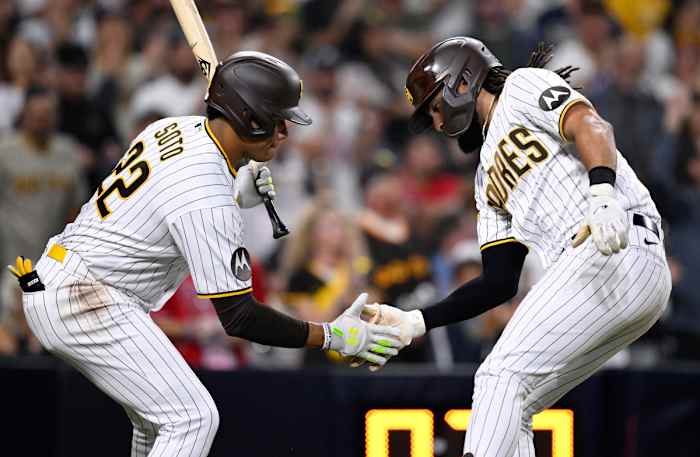 Juan Soto and Fernando Tatis Jr. bend down and high five